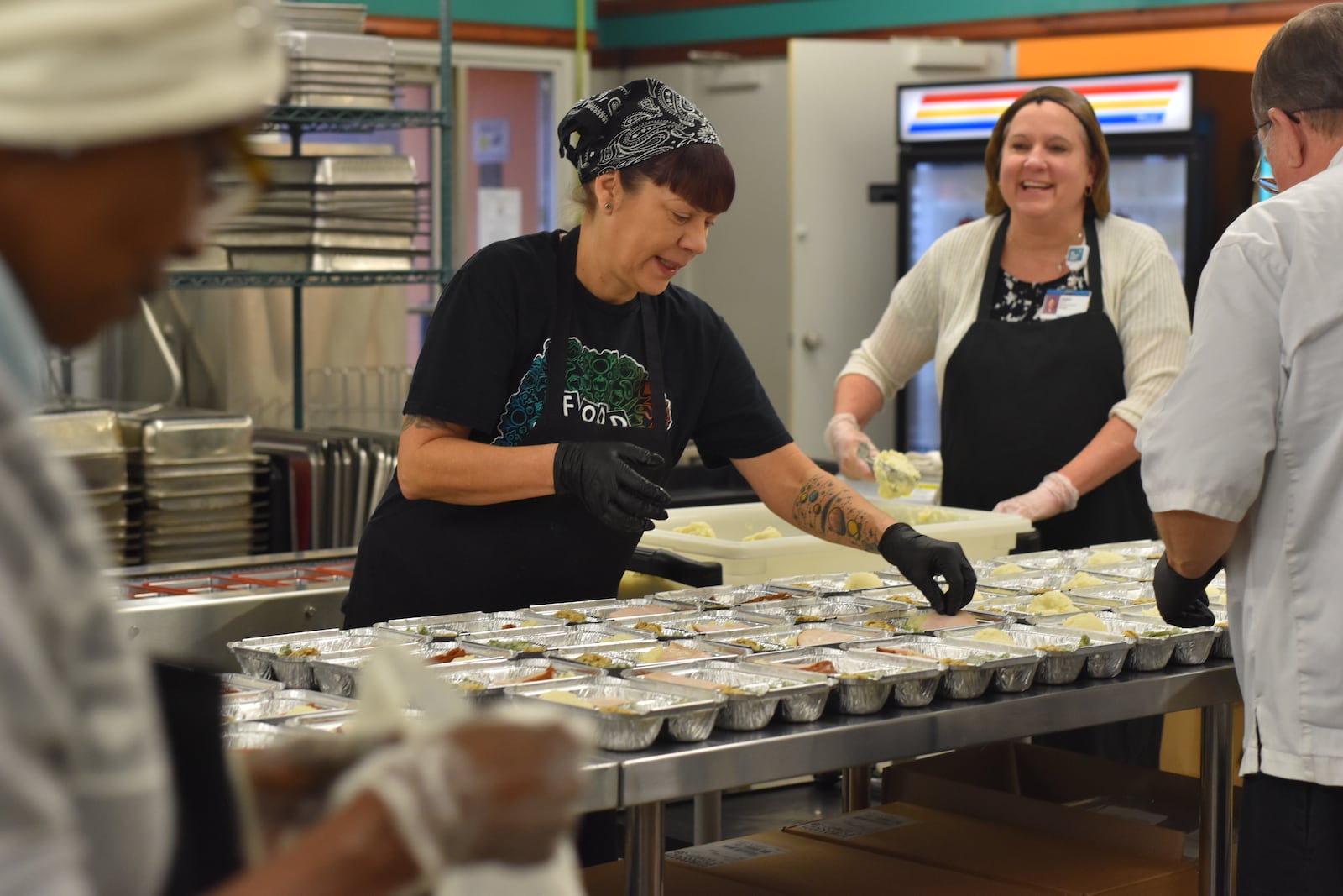 From left, Marilyn Britt, Angela Abnett, Joann Clark and Paul Quinn help prepare Thanksgiving meals on Friday, Nov. 21, 2025 that will be distributed by Miami Valley Meals. Miami Valley Meals will be giving these meals away free of charge on Wednesday, Nov. 26, at two different distribution sites, including between 9 a.m. and 11 a.m. at Trotwood-Madison High School and then between noon and 2 p.m. at the event center Fairborn Phoenix. CORNELIUS FROLIK / STAFF