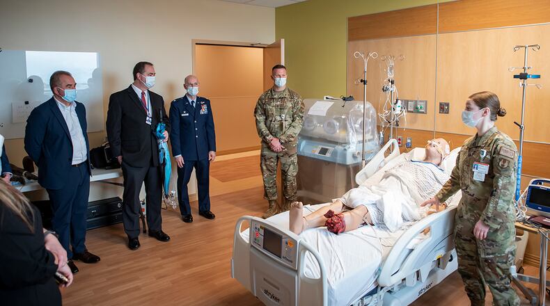 Master Sgt. Amanda Orvis (right), superintendent, Enlisted Critical Care Course, U.S. Air Force School of Aerospace Medicine; and Maj. Kyle Perry (center), chief of enlisted critical care division, USAFSAM, give officials, including Col. Tory Woodard (left-center), commander, USAFSAM, a tour of the new training space during the official opening of the EECC at the Soin Medical Center April 13 in Beavercreek. U.S. AIR FORCE PHOTO/RICHARD ELDRIDGE