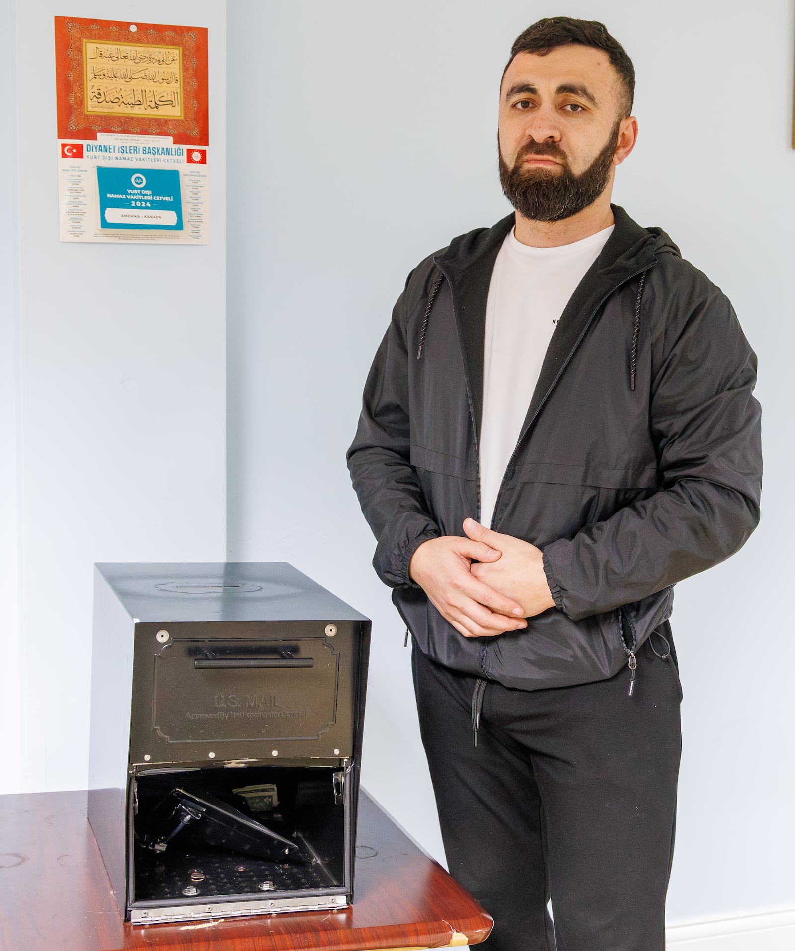 Ali Shakhbandarov, a leader of Ahiska Turkish Community Center on East Fifth Street in Dayton, poses by a donation box in the center's prayer room on Wednesday, Dec. 31.. Security cameras filmed what appears to be a man in a heavy jacket breaking into and stealing money from the donation box on Tuesday night. BRYANT BILLING/STAFF