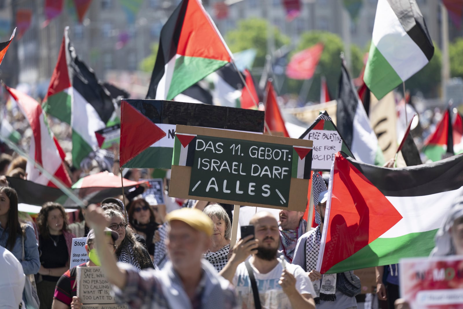 Pro Palestinian protesters demonstrate, during the opening ceremony of the 69th Eurovision Song Contest, in Basel, Switzerland, Sunday, May 11, 2025. Sign read, '11th Commandment: Israel is allowed to do everything.' (Peter Schneider/Keystone via AP)