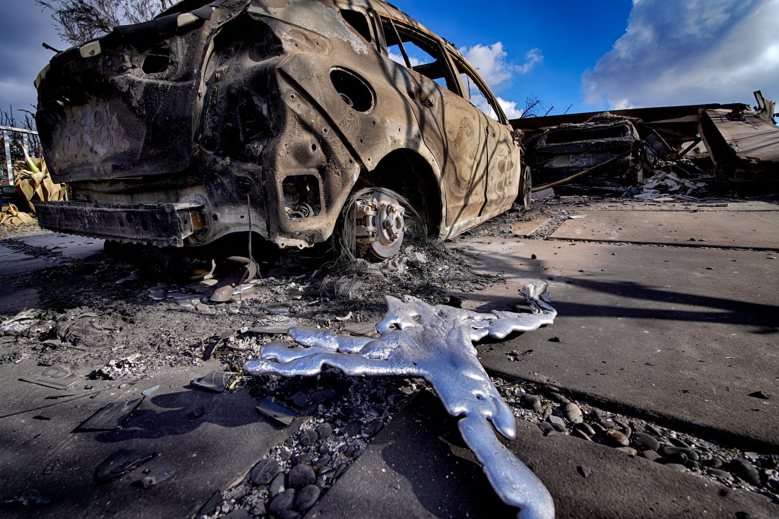FILE - Melted metal and burned out cars sit destroyed in a driveway of a home burned by the wildfire that spread through the Pacific Palisades neighborhood of Los Angeles on Friday, Jan.17, 2025. (AP Photo/Richard Vogel, File)