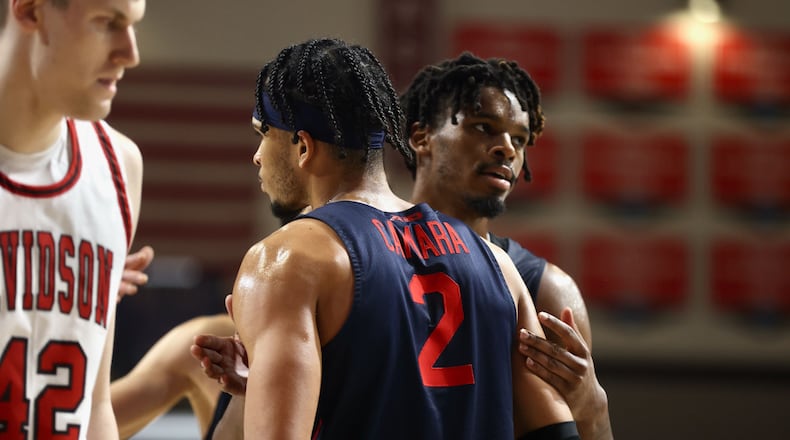 Dayton's Toumani Camara and DaRon Holmes II celebrate a basket against Davidson on Saturday, Dec. 31, 2022, at Belk Arena in Davidson, N.C. David Jablonski/Staff