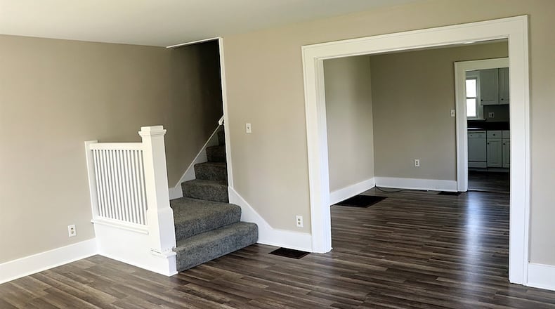 A carpet-covered staircase leads from the living room to the upstairs. The carpeting continues into the hallway and the bedrooms.