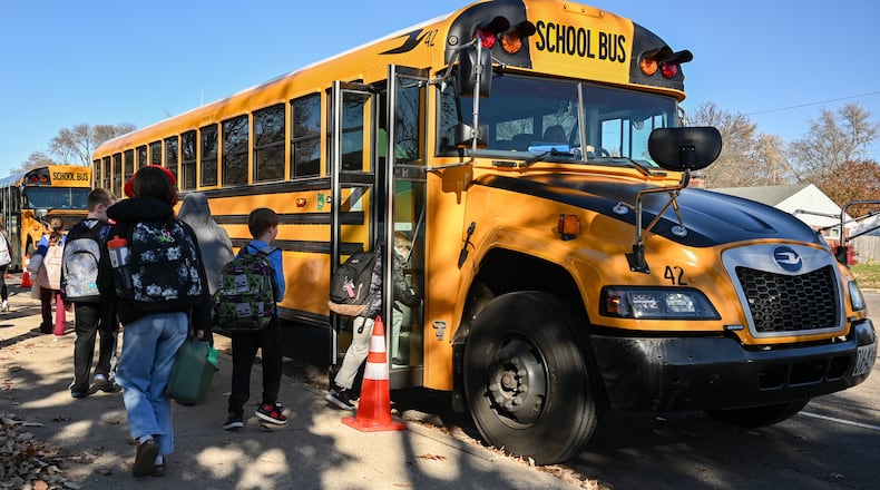 Students walk in a bus pickup lane near Oakview Elementary School on Monday, Nov. 17 in Kettering. BRYANT BILLING/STAFF