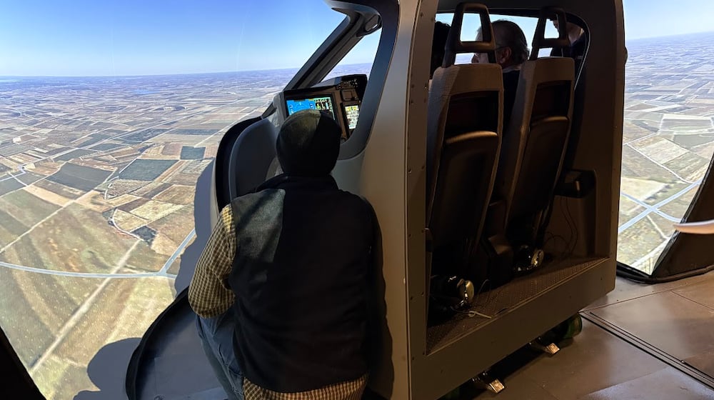 Participants in a Sinclair Community College ground school at Springfield-Beckley Municipal Airport take a "ride" on a simulator meant to impart the experience of flying a Beta Technologies electric plane on Thursday, Feb. 5, 2026. THOMAS GNAU/STAFF
