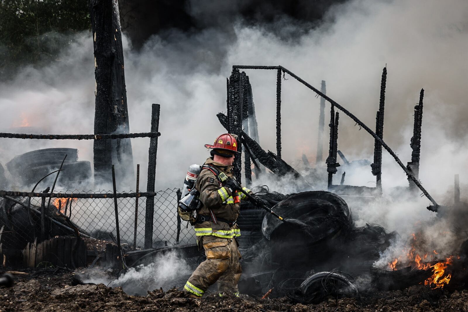 Crews fight a blaze in a pile of tires on Leonhard Street in Dayton May 20, 2024. JIM NOELKER/STAFF