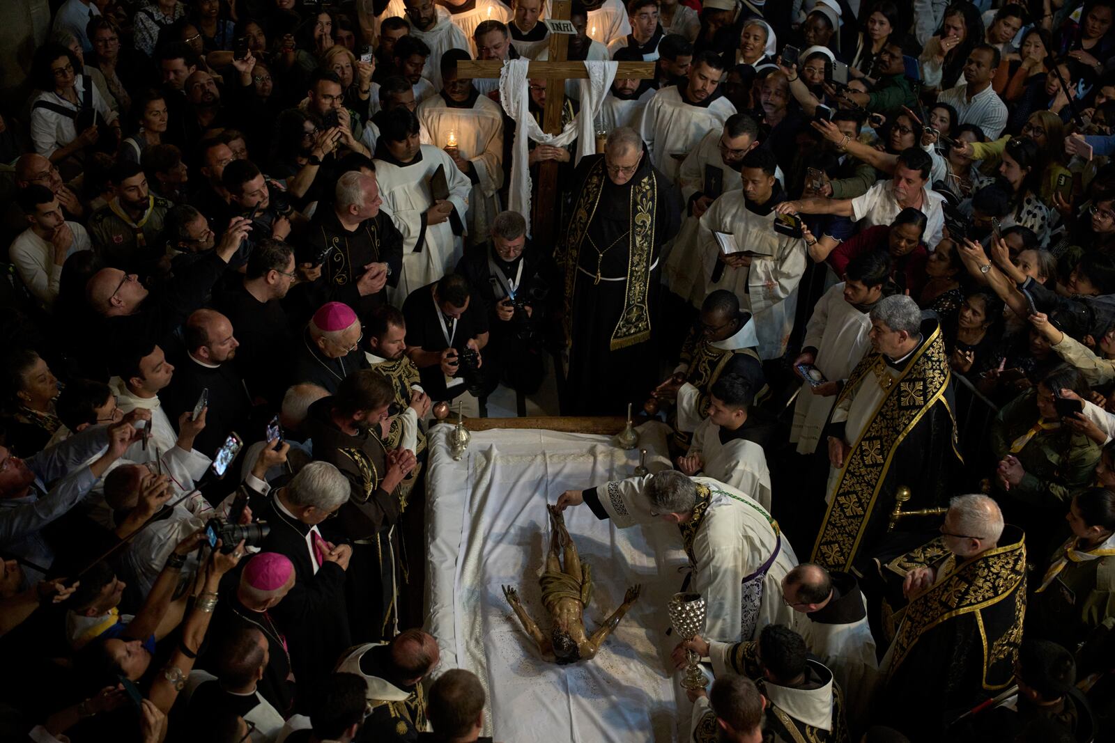 Catholic clergymen take part in a Good Friday ceremony reenacting the funeral of Jesus Christ at the Church of the Holy Sepulcher, the site where according to tradition Jesus was crucified and buried, in the Old City of Jerusalem on Friday, April 18, 2025. (AP Photo/Leo Correa)