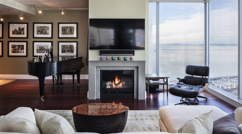 John and Jan Drinkard brought the Eames lounge chair, the stately grand piano and John s black-and-white photographs to the dcor of their downtown condominium s living room and entryway, where interior designer Lindsey Runyon used Benjamin Moore s Providence Olive paint for the accent wall. The custom Tibetan runner at left is by Lapchi, from Driscoll Robbins Fine Carpets. The wool in the rug is hand-carded and hand-woven with silk, and the rug is RugMark-certified, she says. The paint we did after the rugs; that s my system. (Steve Ringman/Seattle Times/TNS)