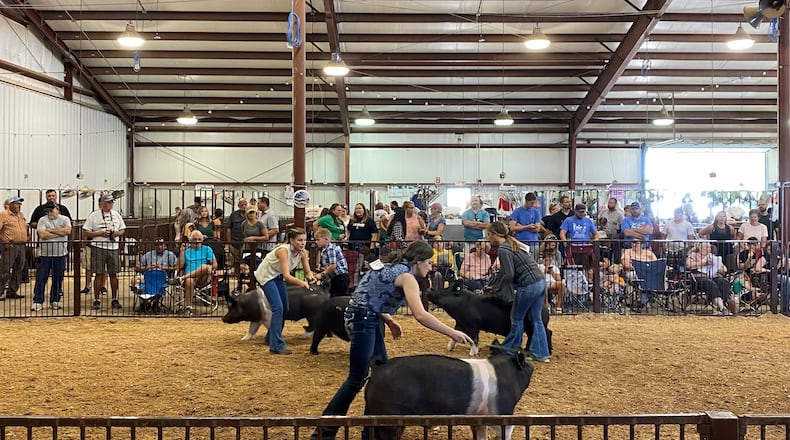 Emma Schnecker, middle, shows her hog, "Magic Mike" Tuesday at the Greene County Fair. Schnecker won the Junior Fair Market Hog competition.