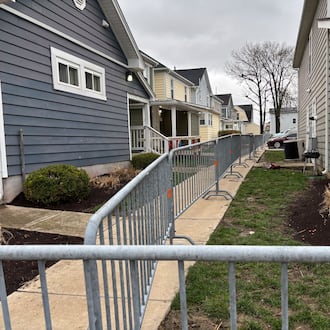 The city of Dayton has begun putting up fencing on Lowe Street Friday morning in anticipation of St. Patrick's Day festivities this weekend. Eileen McClory / staff