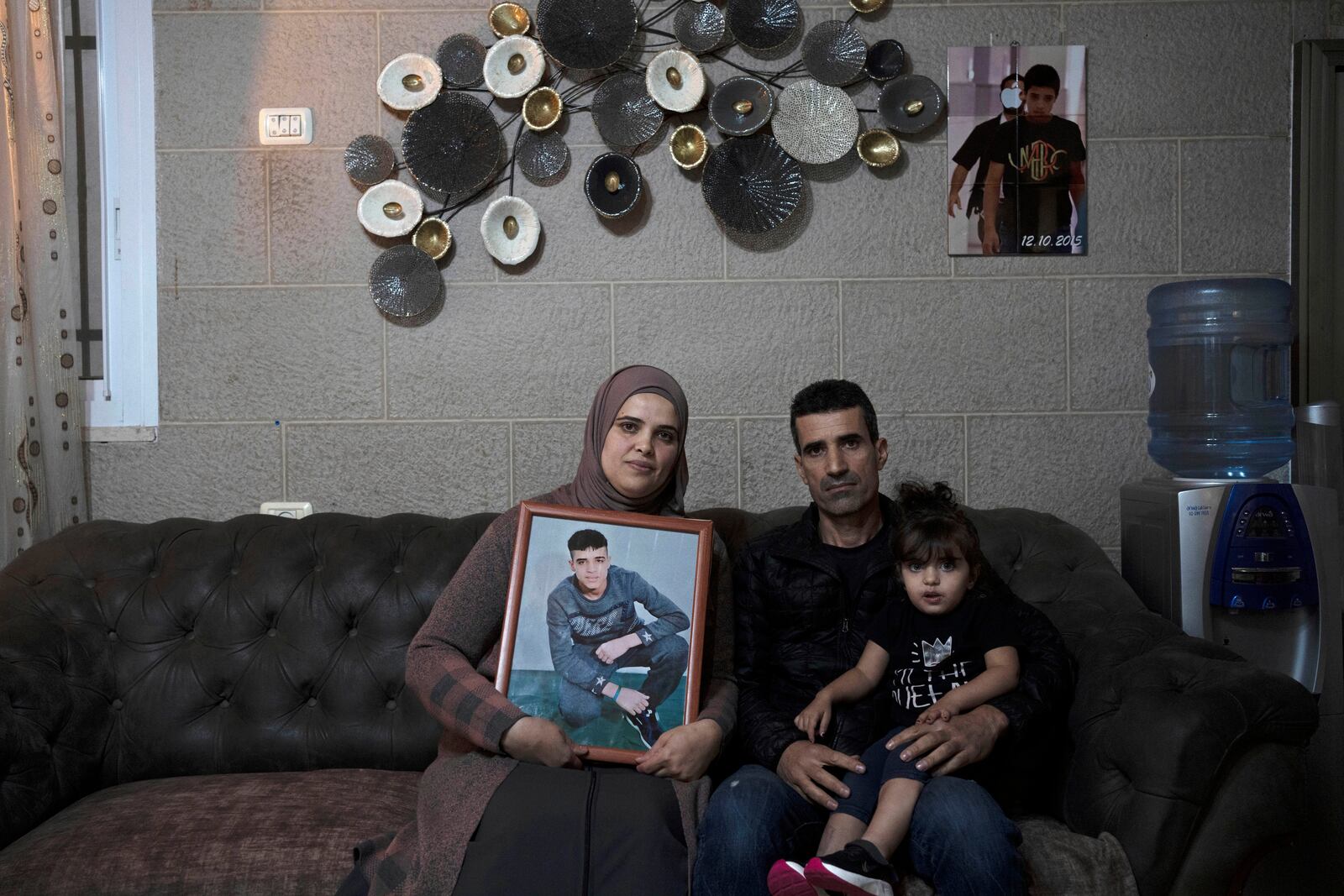 FILE - Maysoon, left, and Saleh Manasra, parents of Ahmad Manasra, who has been imprisoned by Israel since he was 13 when he was was convicted of attempted murder and sentenced to nine and a half years in prison, after his older cousin stabbed two Israelis, pose for a portrait with their daughter, Sham, in their home in east Jerusalem, Tuesday, Nov. 8, 2022. (AP Photo/ Maya Alleruzzo, File)