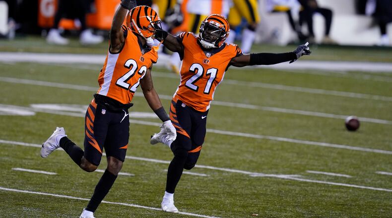Cincinnati Bengals' William Jackson (22) and Mackensie Alexander (21) celebrate after Pittsburgh Steelers turned the ball over on downs during the second half of an NFL football game, Monday, Dec. 21, 2020, in Cincinnati. (AP Photo/Michael Conroy)
