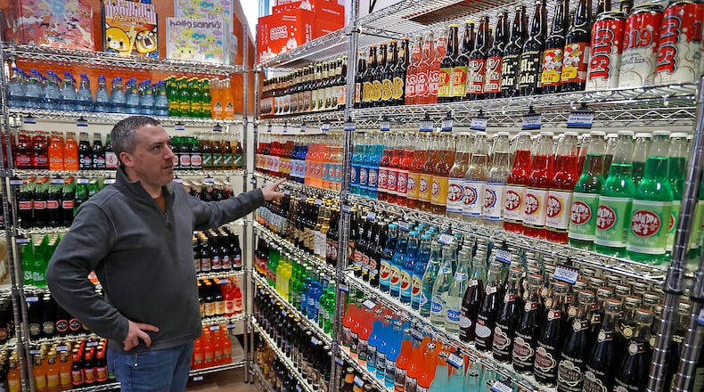 Chris Beers, owner of Grandpa Joe's Candy Shop, talks about the variety of soda flavors the new candy shop will carry including pickle soda and ketchup soda Monday, Nov. 14, 2022. BILL LACKEY/STAFF