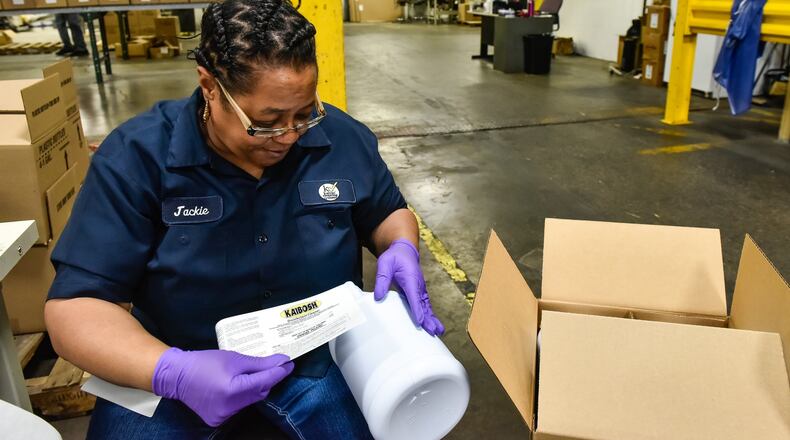 Jackie Brewster puts labels on bottles of KaiBosh disinfectant cleaner Wednesday, April 8, 2020 at Kaivac Cleaning Systems in Hamilton. Kaivac would normally get preprinted bottles but some of their suppliers are having a hard time keeping up with demand so they are having labels printed and getting blank bottles to fill with product to meet their customer demands. Kaivac makes cleaning products and machines for a variety of industries. NICK GRAHAM / STAFF