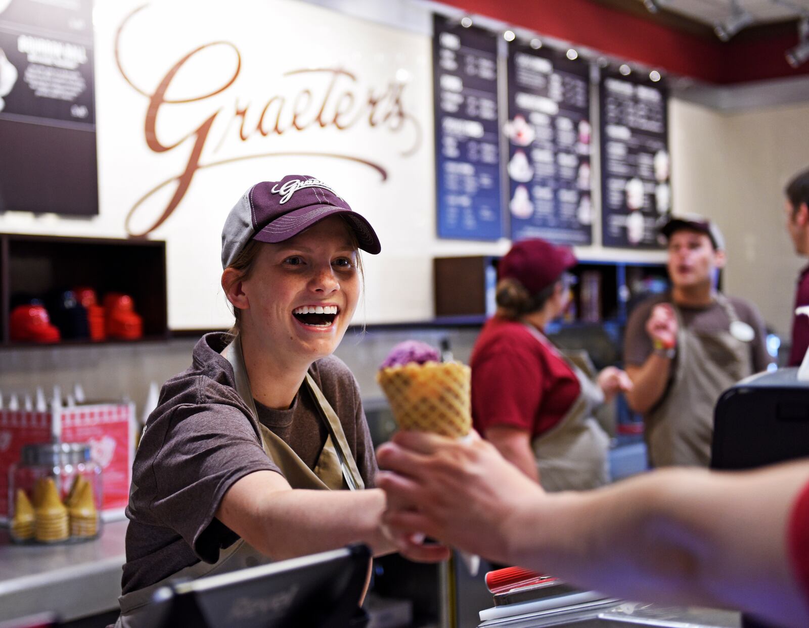 Katie Bowling hands an ice cream cone to a customer during opening day Monday, July 6, 2015, of the new Graeter's Ice Cream in Oxford. Traffic was brisk throughout the 80-degree afternoon, with the store performing in line with expectations, said District Manager Dave Raters, who was on hand for the opening at 29 W. High St. The chain s other Butler County location is at Cox Road in West Chester Twp. The Oxford store employs about 20 people and is still hiring. Richard Graeter, the president and CEO of the company, is a Miami University alumnus, class of 1986. NICK GRAHAM/STAFF