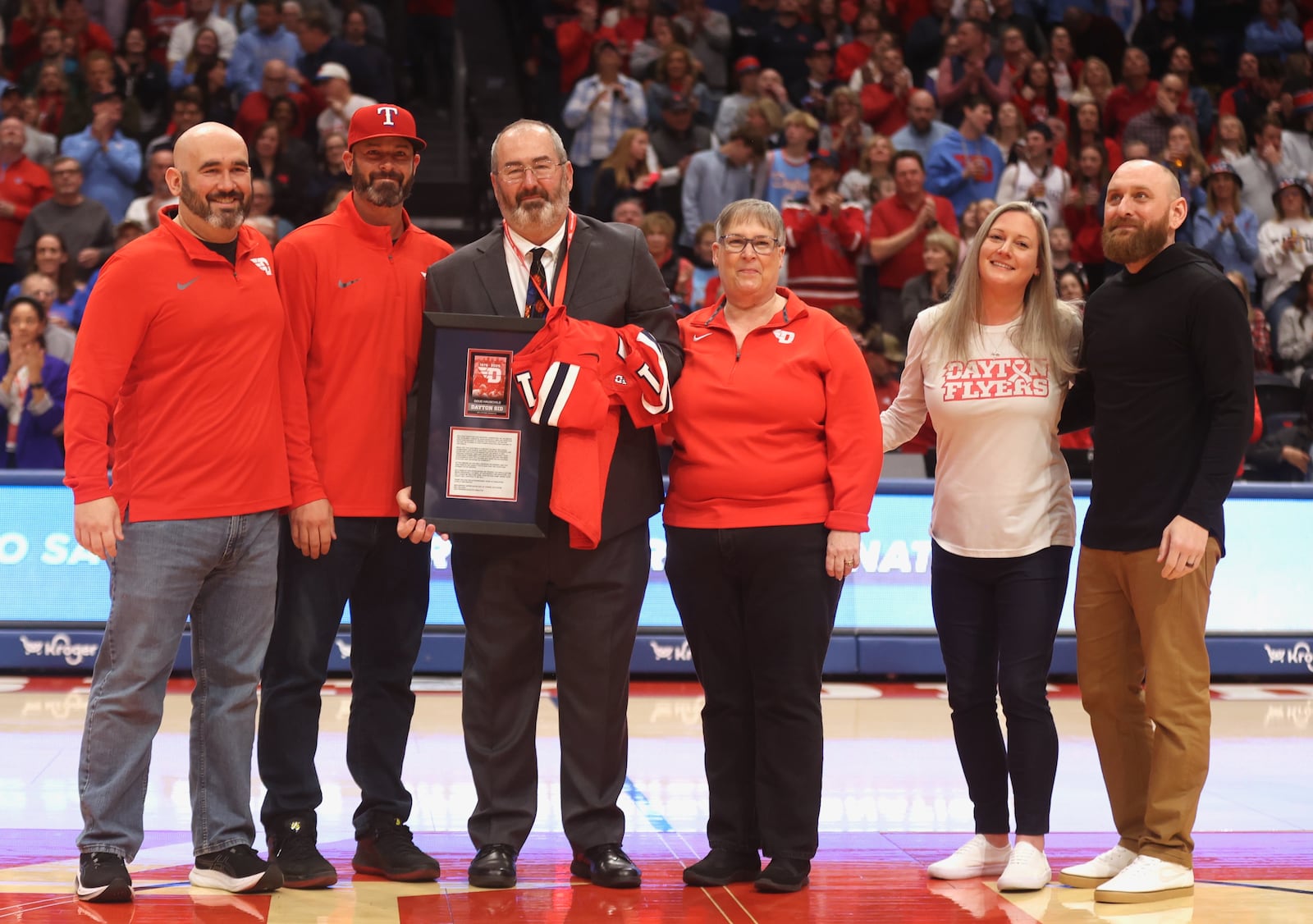 Dayton's Doug Hauschild, who is retiring after the school year, is honored during a timeout in the second half of a game against Loyola Chicago on Saturday, Jan. 18, 2025, at UD Arena. David Jablonski/Staff
