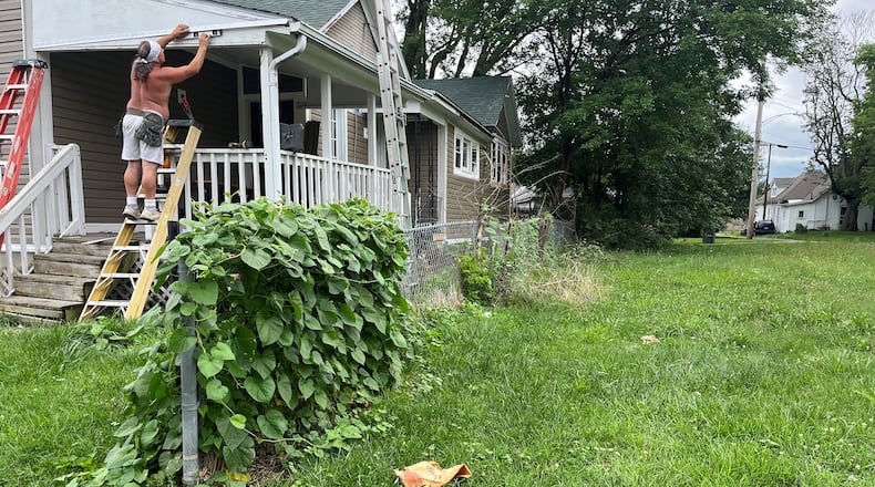 A man works on renovating a home next to an empty lot that the city of Dayton owns on Hawker Street in the Twin Towers neighborhood. The city owns multiple empty lots on the 100 and 200 blocks of Hawker Street. CORNELIUS FROLIK / STAFF