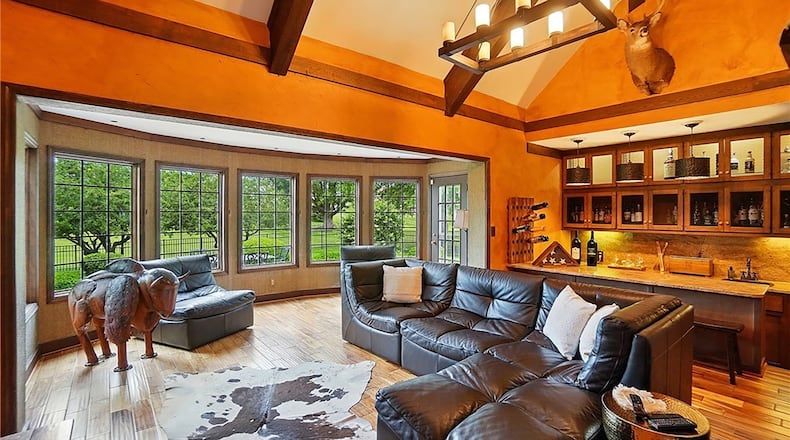 the family room has beamed ceilings and a wet bar with wood cabinets and a copper bar sink.
