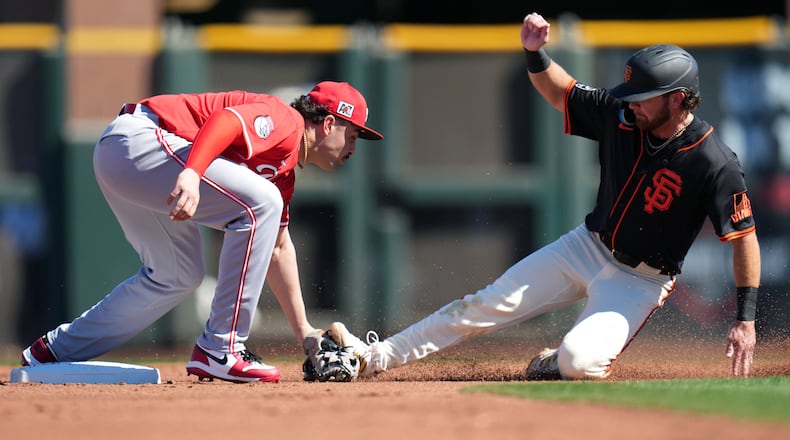 Cincinnati Reds second baseman Sal Stewart, left, tags out San Francisco Giants' Brett Wisely, right, as Wisely tries to steal second during the second inning of a spring training baseball game Sunday, Feb. 23, 2025, in Scottsdale, Ariz. (AP Photo/Ross D. Franklin)