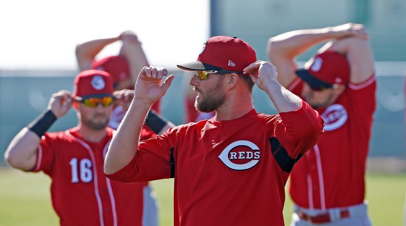 Cincinnati Reds’ Tucker Barnhart (16), Zack Cozart, middle, and Adam Duvall, right, all stretch out at the team’s baseball spring training facility Monday, Feb. 20, 2017, in Goodyear, Ariz. (AP Photo/Ross D. Franklin)
