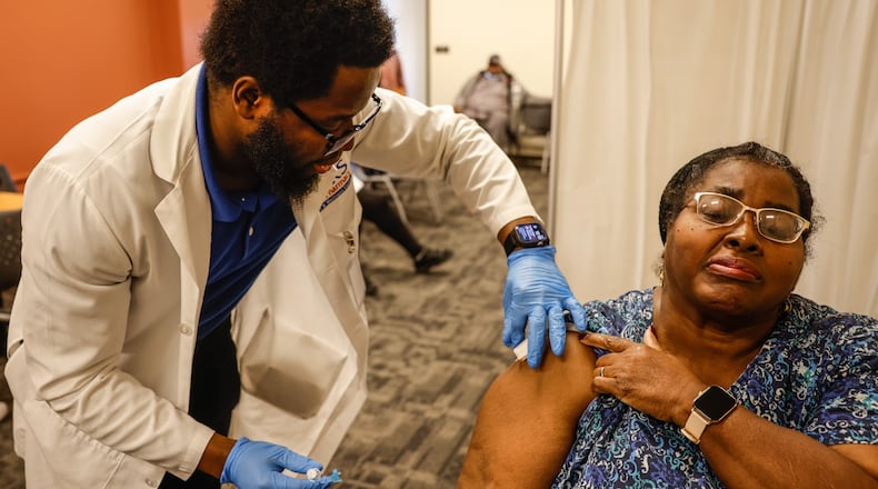 Lisa Tingle, from Dayton, receives a flu shot from Ziks Clinical Pharmacist, Emmanuel Ayanjoke at the store Friday Dec. 3, 2021. Flu vaccines are urged ahead of Christmas time gatherings and to help prevent twin surges of flu and COVID-19. JIM NOELKER/STAFF