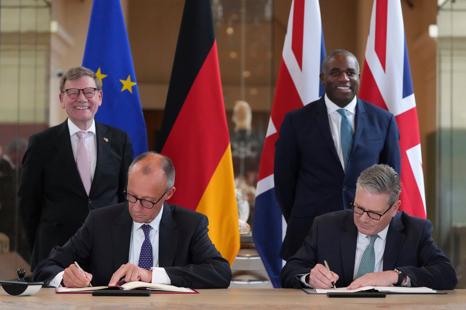 Britain's Prime Minister Keir Starmer, right, and German Chancellor Friedrich Merz, left, with Germany's Minister for Foreign Affairs Johann Wadephul, behind left, and Britain's Foreign Secretary David Lammy, behind right, as they attend a signing ceremony of a wide-ranging bilateral cooperation treaty in London, Thursday, July 17, 2025.(AP Photo/Frank Augstein, Pool)
