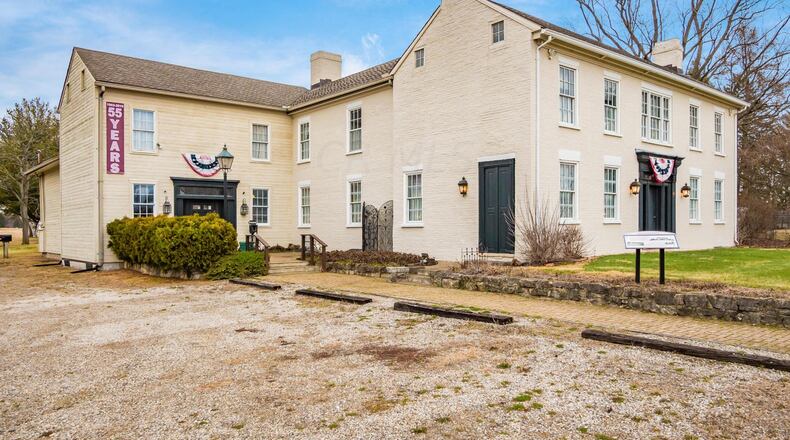 The historical property has an addition in the back and the original brick residence in the front.