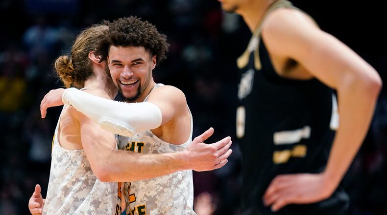 Wright State's Tanner Holden, center right, embraces Tim Finke during a game stoppage in the final second of the second half of a First Four game against Bryant in the NCAA men's college basketball tournament against Bryant, Wednesday, March 16, 2022, in Dayton, Ohio. (AP Photo/Jeff Dean)