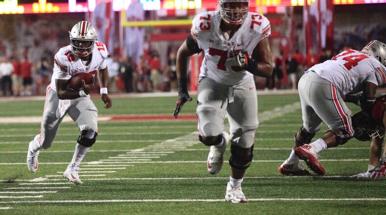 Ohio State's J.T. Barrett, left, runs behind Michael Jordan during a game against Indiana on Thursday, Aug. 31, 2017, at Memorial Stadium in Bloomington, Ind. David Jablonski/Staff