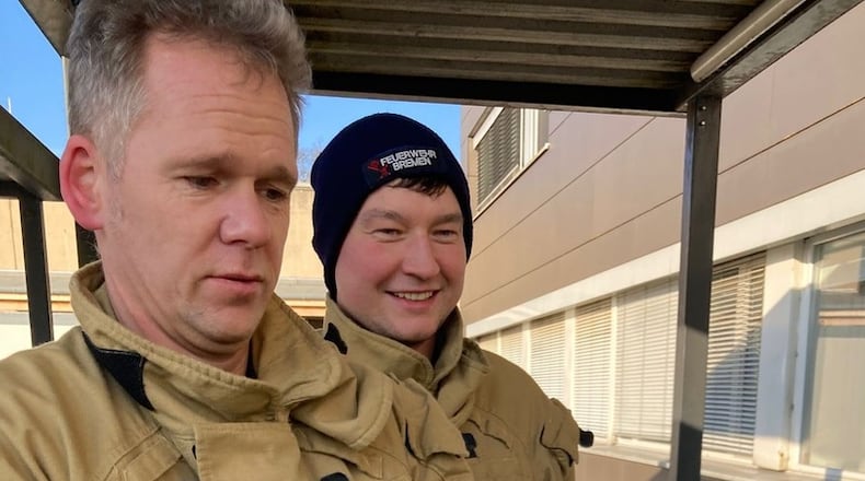A firefighter from the Bremen Fire Department holds an injured cormorant that had pecking at the door of an emergency room at a hospital in Bremen, Germany, Sunday, Feb. 15, 2026. (Feuerwehr Bremen/ DPA via AP)