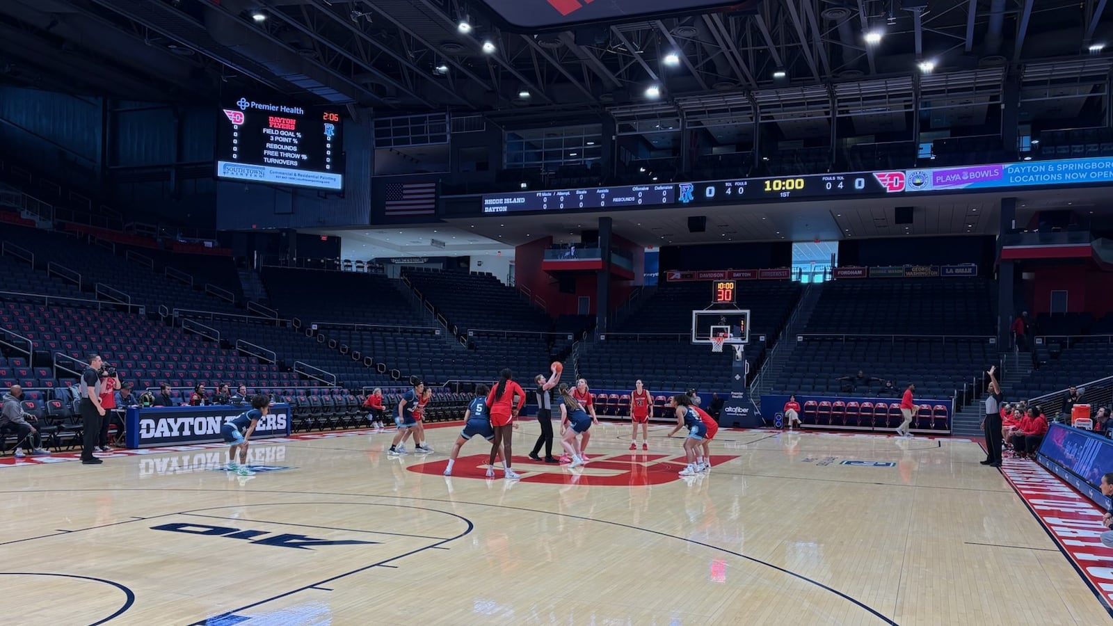 In a game played without a crowd because of the severe weather outside, referee Kelsey Reynolds throws up the ball for the opening tip between Rhode Island's 6-foot-5 Abina Syla and Dayton's 6-2 center Molly O'Riordan on Sunday, Jan. 26, 2026 at UD Arena. TOM ARCHDEACON / CONTRIBUTED PHOTO