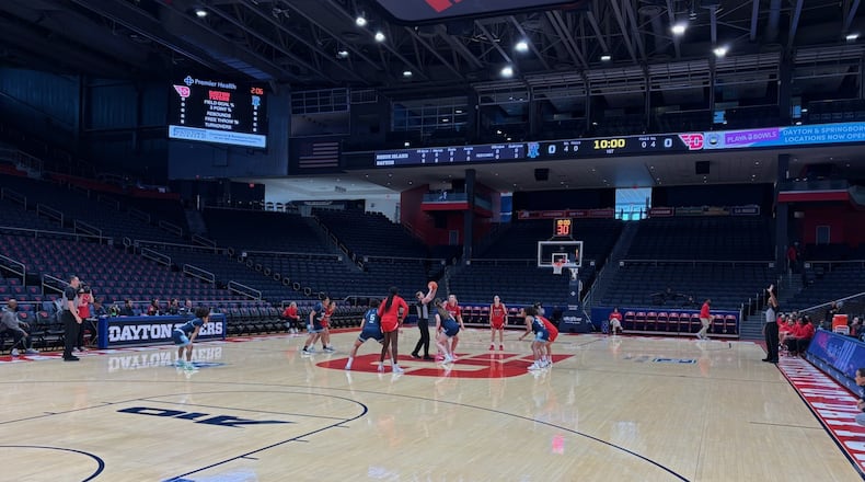 In a game played without a crowd because of the severe weather outside, referee Kelsey Reynolds throws up the ball for the opening tip between Rhode Island's 6-foot-5 Abina Syla and Dayton's 6-2 center Molly O'Riordan on Sunday, Jan. 26, 2026 at UD Arena. TOM ARCHDEACON / CONTRIBUTED PHOTO