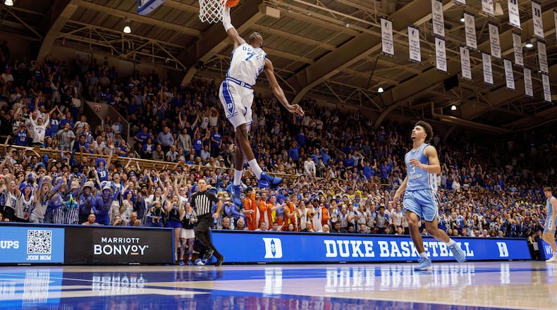 Duke's Dame Sarr (7) dunks ahead of North Carolina's Derek Dixon (3) during the second half of an NCAA college basketball game in Durham, N.C., Saturday, March 7, 2026. (AP Photo/Ben McKeown)