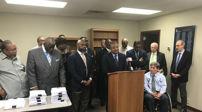 Attorney Michael Wright speaks about the civil rights complaint filed against Premier Health, surrounded by west side clergy who brought the complaint over the planned closure of Good Samaritan Hospital. KAITLIN SCHROEDER/STAFF
