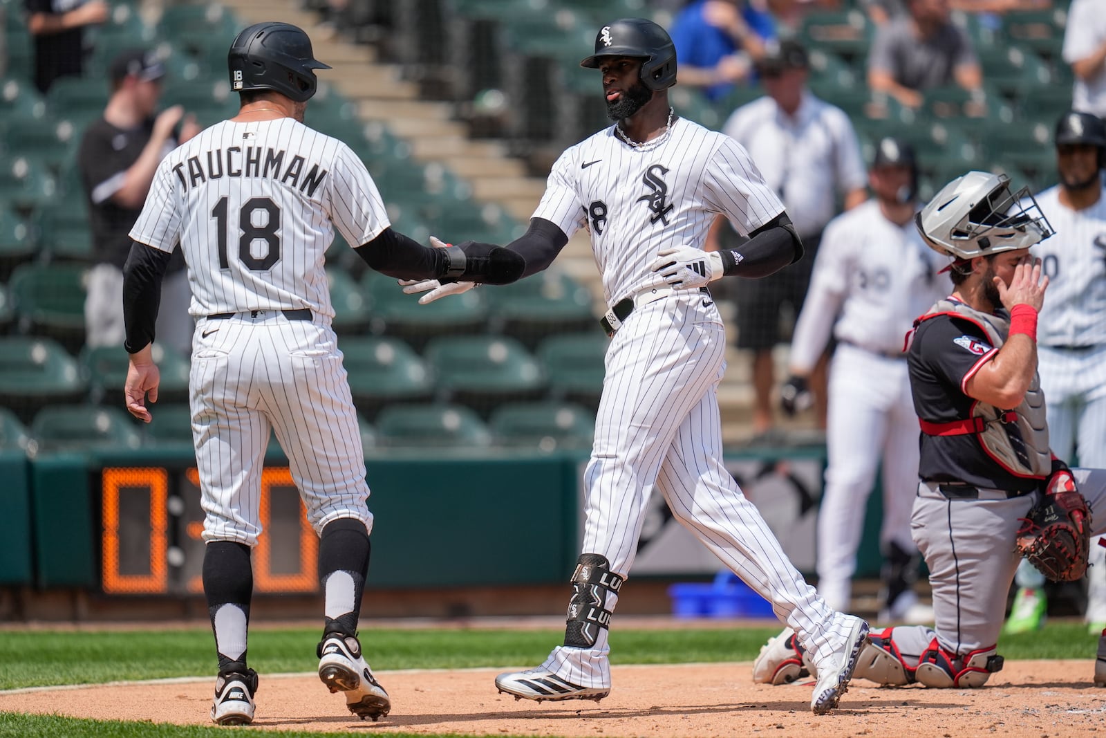 Chicago White Sox's Luis Robert Jr., right, celebrates with Mike Tauchman (18) after hitting a two-run home run during the second inning of the first baseball game of a doubleheader against the Cleveland Guardians, Friday, July 11, 2025, in Chicago. (AP Photo/Erin Hooley)