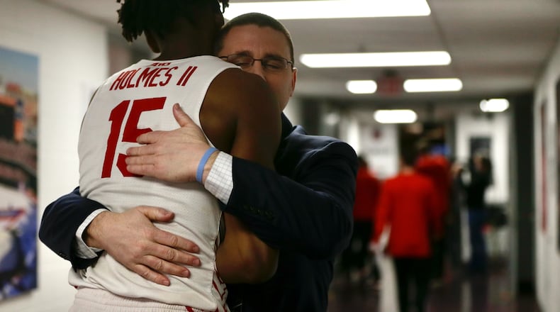 Dayton Athletic Director Neil Sullivan hugs DaRon Holmes II after a victory against Massachusetts on Friday, March 11, 2022, in the quarterfinals of the Atlantic 10 Conference tournament at Capital One Arena in Washington, D.C. David Jablonski/Staff