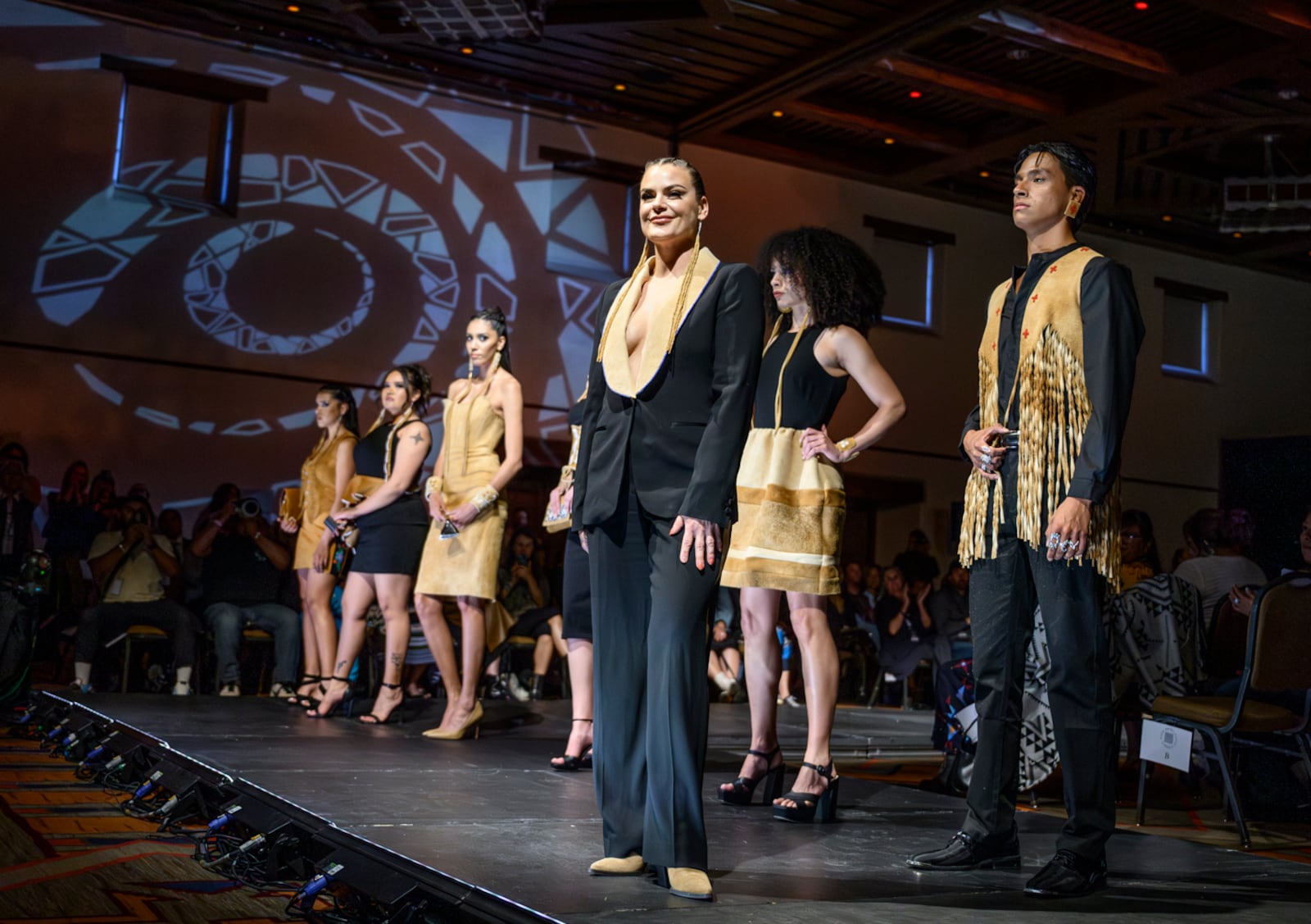 Designer Randi Nelson takes the stage after her runway show at the 2025 Native Fashion Show, Friday, May 9, 2025, in Santa Fe, N.M. (AP Photo/Roberto E. Rosales)