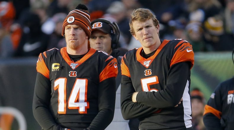 Cincinnati Bengals quarterbacks Andy Dalton (14) and Ryan Finley (5) stand on the sidelines during the second half an NFL football game against the Pittsburgh Steelers, Sunday, Nov. 24, 2019, in Cincinnati. (AP Photo/Frank Victores)