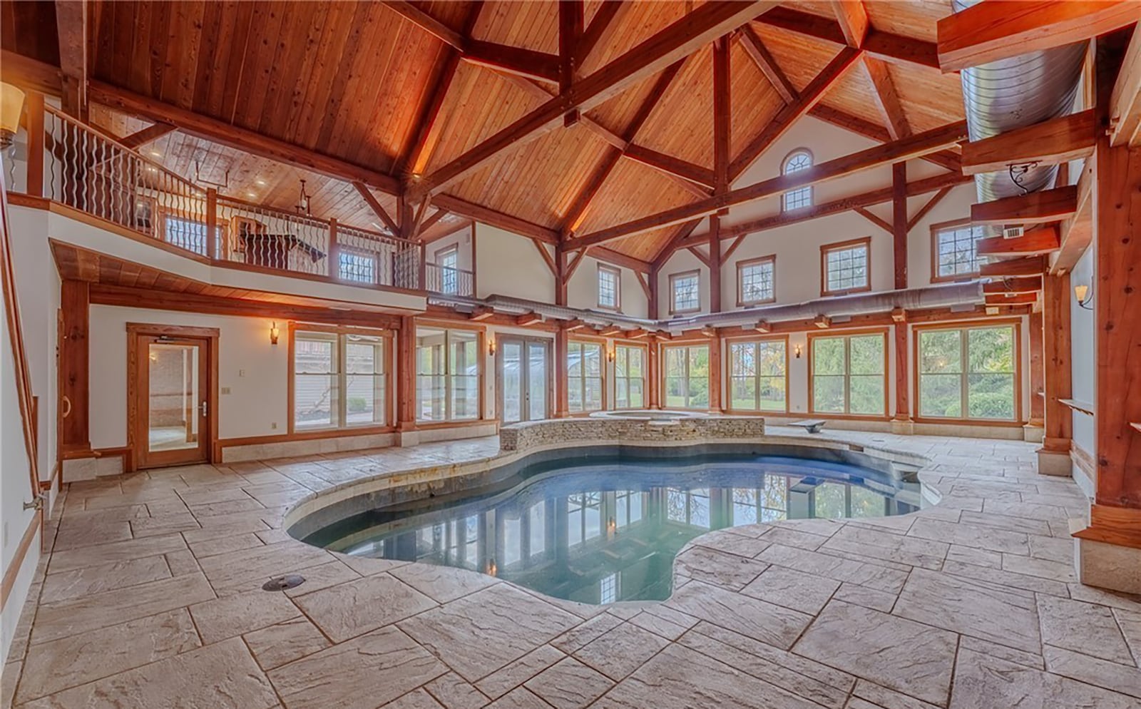 The indoor Gunite pool has an integrated hot tub and diving board. Tile flooring surrounds the pool and the pool room is two story with a wood ceiling and beams. CONTRIBUTED