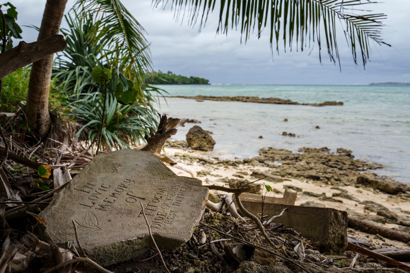 A gravestone lies just feet from the shoreline on Pele Island, Vanuatu, Friday, July 18, 2025. (AP Photo/Annika Hammerschlag)