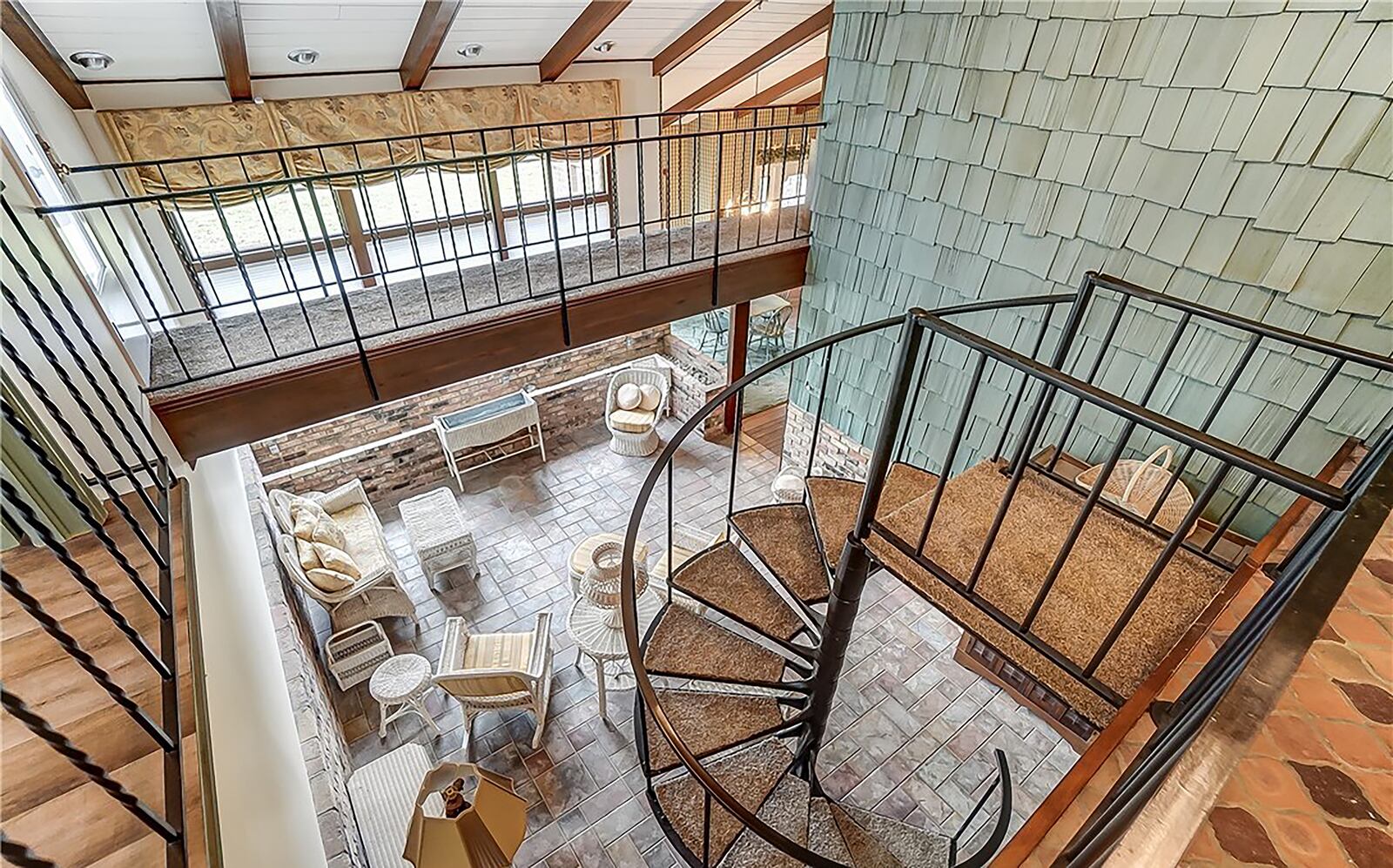 The home has unique features, including this spiral staircase that connects the main level to the lower level. There is also a catwalk with built in bookcases.