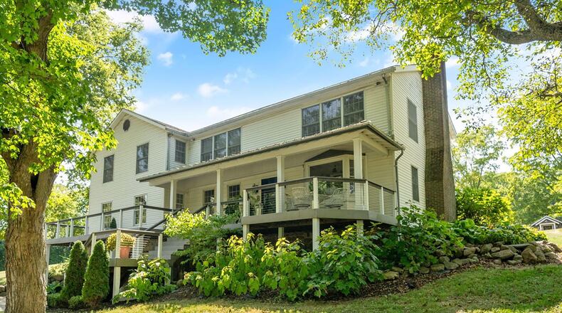 The two story has a covered front porch and a section that wraps around the corner of the house.