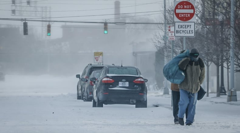 Two pedestrians make their way up Second Street in Dayton in subzero weather Friday morning Dec. 23, 2022. JIM NOELKER/STAFF