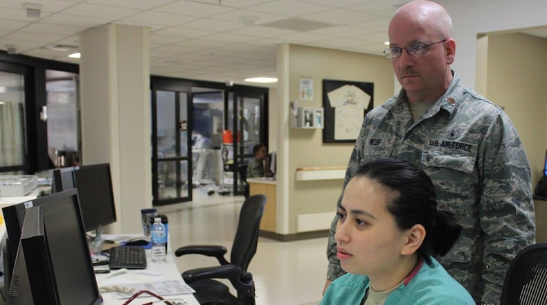 Maj. Gary Webb, 88th Inpatient Operations Squadron Critical Care Flight commander, reviews patient information with Capt. Lady Laarni Domingo, 88th Medical Group Intensive Care Unit nurse and Critical Care Registered Nurse certified. All the military nursing staff in the 88th Medical Group ICU have obtained certification by the American Association of Critical Care Nurses Certification Corporation. Certification reinforces the specialized knowledge and experiences required to care for acute and critically ill patients. (U.S. Air Force photo/Stacey Geiger)