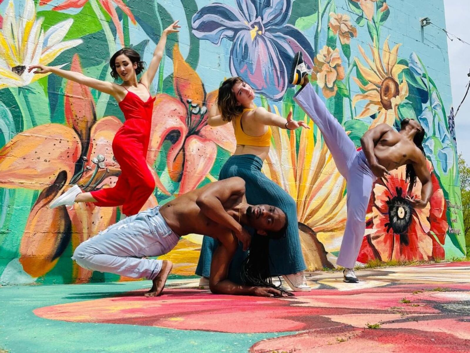 (left to right) Dayton Dance Initiative company members Miranda Dafoe, Devin Baker, Emilia Dagradi, and Quentin Sledge. (Mural by Tiffany Clark).
