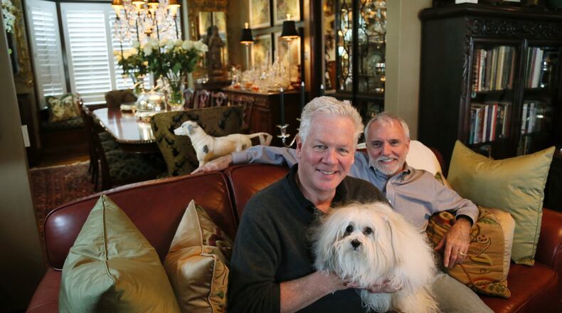 Craig Burfield (left), John Nellesen and Victoria, a four-year-old Coton de Tulear, in their home in the Carondelet neighborhood on Thursday, Aug. 19, 2018, in St. Louis. (Chris Lee/St. Louis Post-Dispatch/TNS)