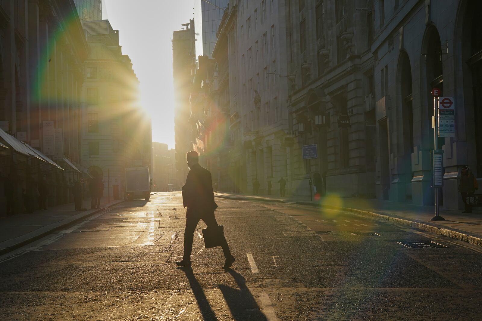 A man walks in the the City of London financial district, London, Tuesday, April 8, 2025. (AP Photo/Alberto Pezzali)