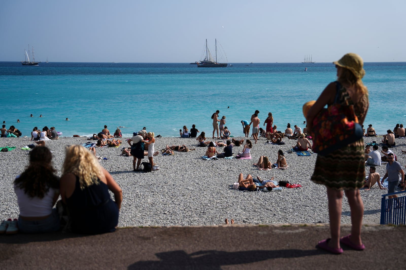 People enjoy the beach as vessels sail during the "Ocean Wonders" event in honor of World Oceans Day ahead of the U.N. Ocean Conference on Sunday, June 8, 2025, in Nice, France. (AP Photo/Annika Hammerschlag)
