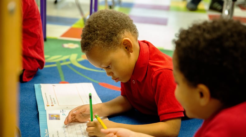 Children work in a workbook. Courtesy of Learn to Earn Dayton.