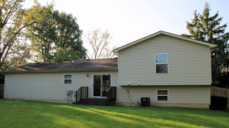 Patio doors off the dining room open to a deck and the back yard surrounded by a corral fence.